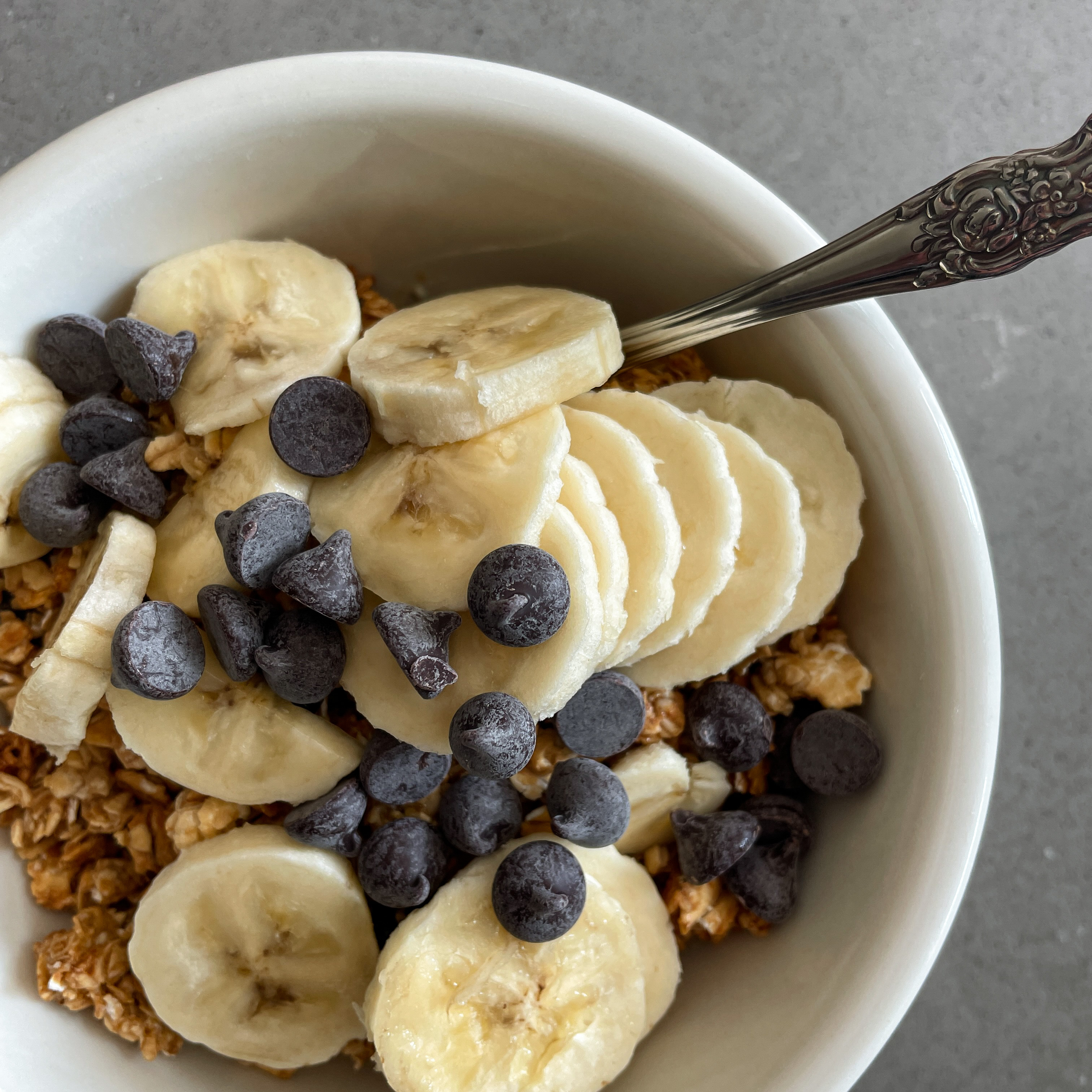 yogurt and granola topped with sliced banana and chocolate morsels