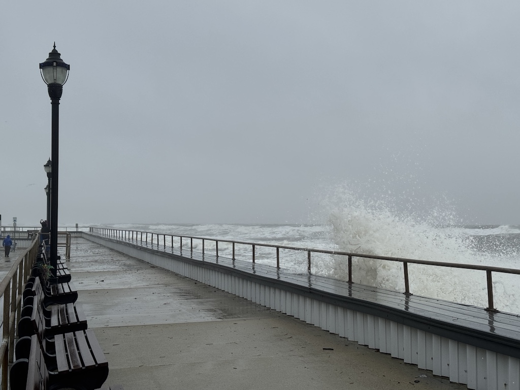 Waves crash against the seawall on Monday, October 13, 2025.