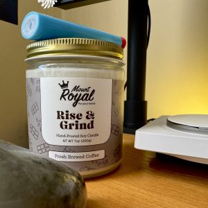 Photo of a candle sitting on the author's desk. Candle is from Mount Royal Soaps, scent is "Rise & Grind."
